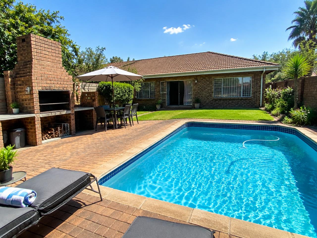 Outdoor swimming pool and braai area at Zea85 B&B